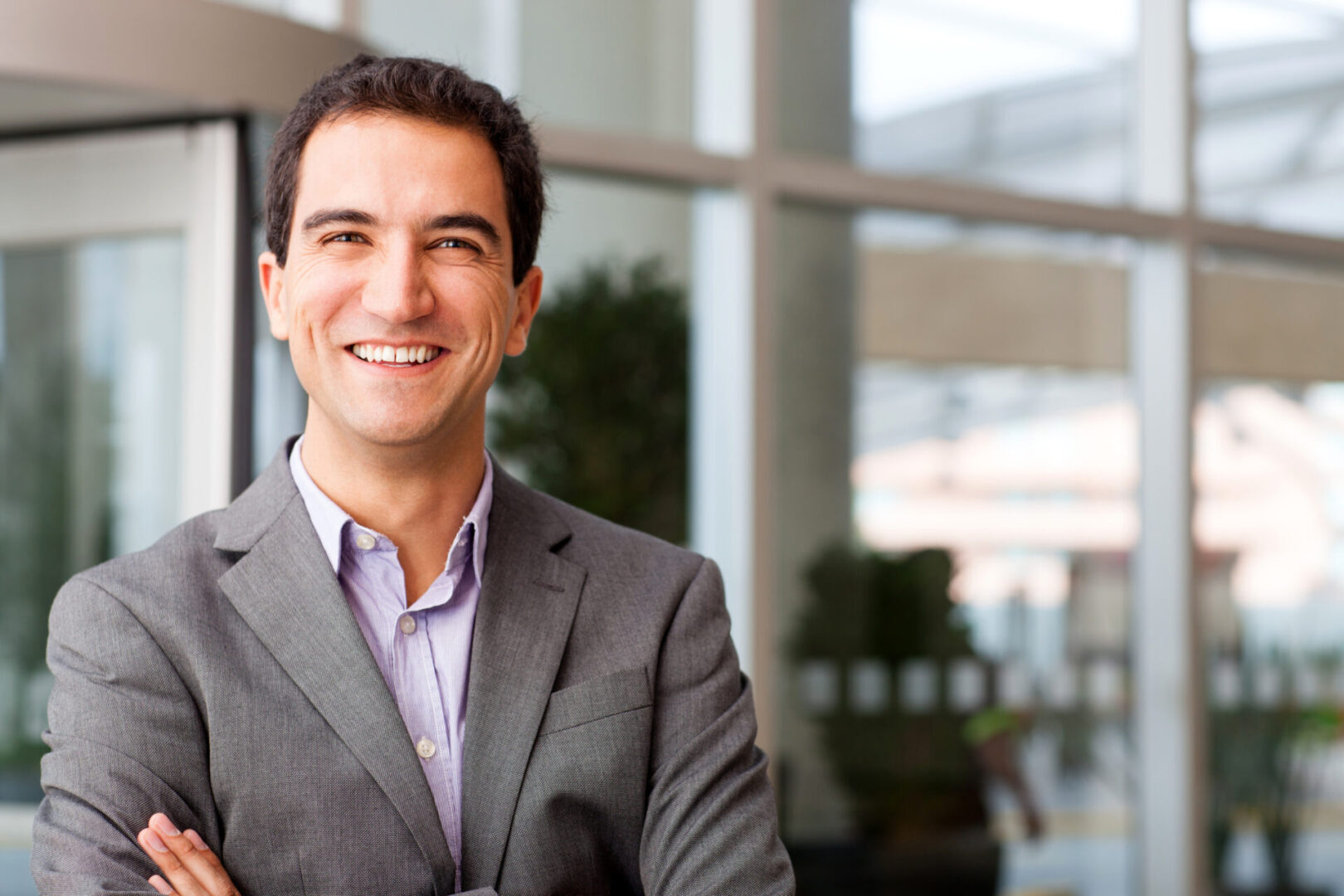 Happy young businessman smiling at the office