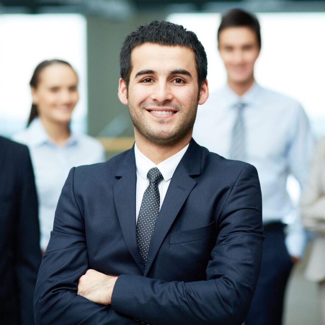 Group of friendly businesspeople with male leader in front